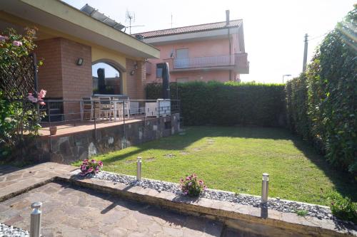 a house with a yard with some flowers in it at Moderna villa con piscina a due Passi dal Golf Club in Pavona
