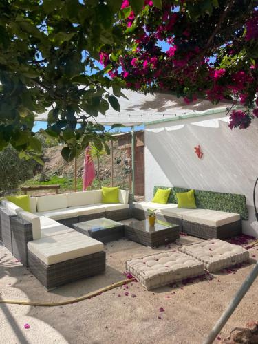 een patio met banken, een tafel en bloemen bij Cortijo Maya, maison troglodyte pour 10 personnes in Alhama de Almería