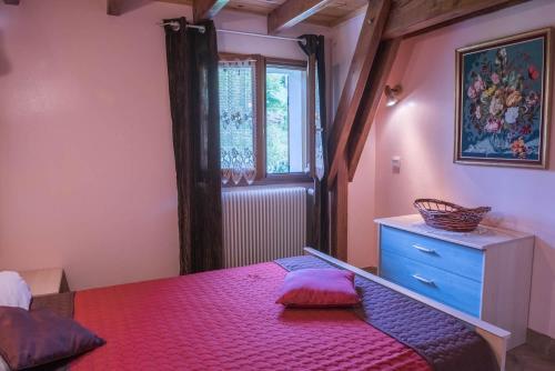 - une chambre avec un lit rouge et une fenêtre dans l'établissement Gîte 