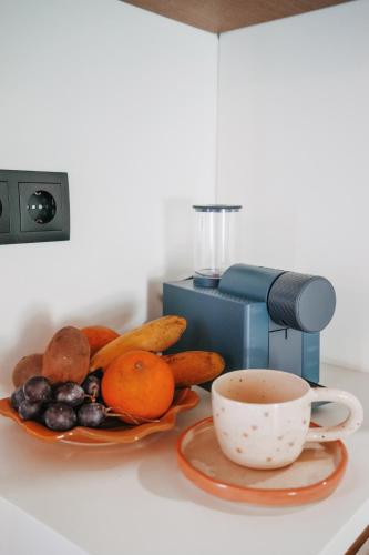 a cup of coffee sitting next to a plate of fruit at Casa da Veiga de Ponte de Lima in Ponte de Lima