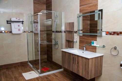 ein Badezimmer mit Waschbecken und Dusche in der Unterkunft Hotel Next in Masaka