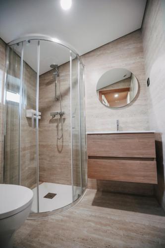 a bathroom with a shower with a toilet and a mirror at Casa da Veiga de Ponte de Lima in Ponte de Lima