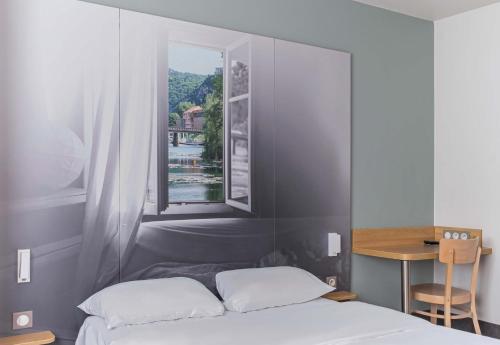 a bedroom with a bed and a window at B&B HOTEL Besançon Chateaufarine in Besançon