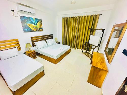 Una habitación de hotel con dos camas y una ventana. en The Cottage Ambuluwawa, en Gampola