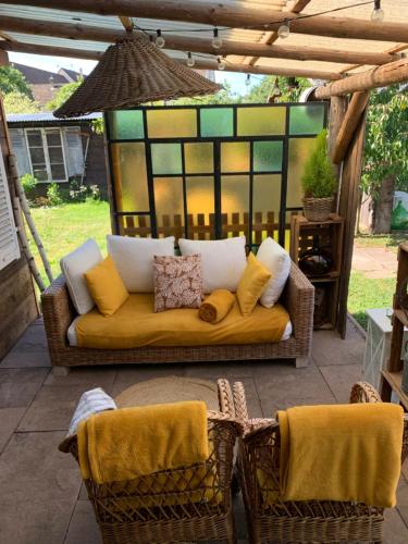 a couch sitting on a patio with two chairs at Cab’âne in Guémar