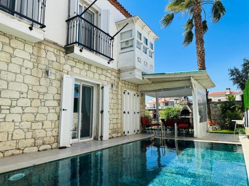 a house with a swimming pool in front of a building at Evalacati - Villa Palma-Tamamen Müstakil Villa in Cesme