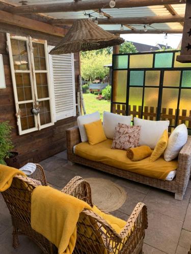a couch on a patio with chairs and an umbrella at Cab’âne in Guémar