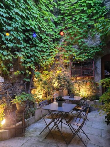 a table and chairs in a garden with a tree at Chambres d hôtes Le clos des vins d anges in Saint-Pierre-des-Champs