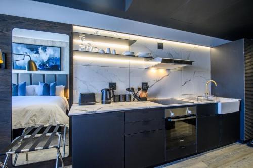a kitchen with a sink and a bed in a room at The Capital Pearls Hotel in Durban