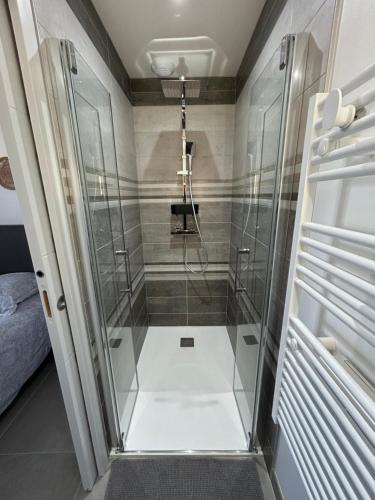 una ducha con puerta de cristal en un baño en T2 neuf avec terrasse privative proche gare, en Rochefort