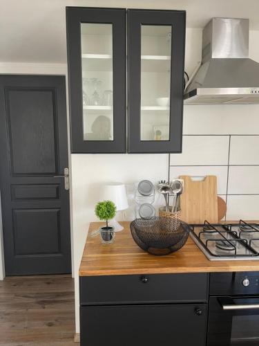 une cuisine avec des armoires noires et un comptoir en bois dans l'établissement Bas de villa, à Istres