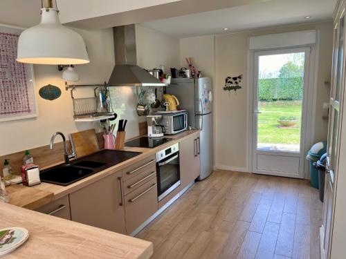 une cuisine avec un évier et un réfrigérateur dans l'établissement Villa Sakura, à Beaumont-en-Auge