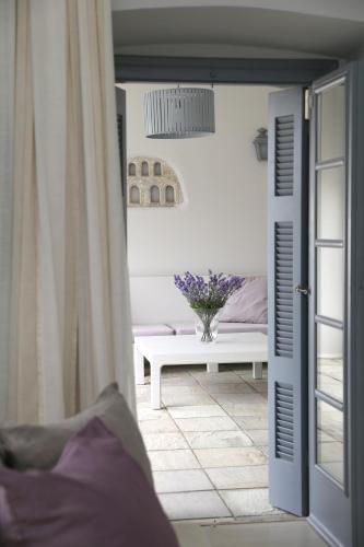 a room with a table and a vase of flowers at Micra Anglia Boutique Hotel & Spa in Andros