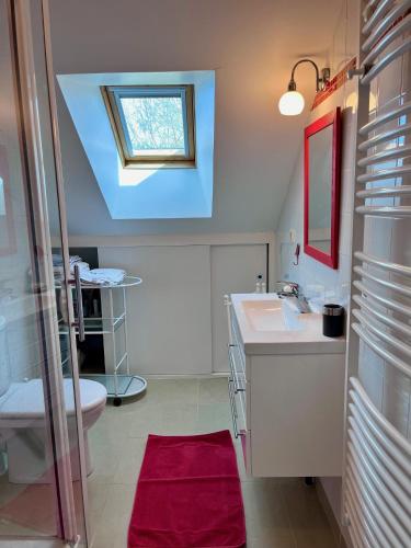 une salle de bain avec un lavabo et des toilettes et une fenêtre dans l'établissement Villa Sakura, à Beaumont-en-Auge