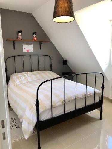 une chambre avec un lit dans un grenier dans l'établissement Villa Sakura, à Beaumont-en-Auge