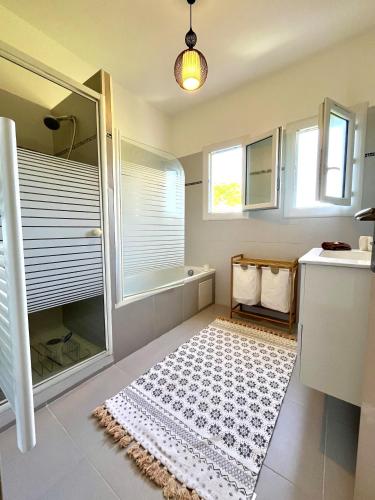 La salle de bains est pourvue d'une douche et d'un tapis. dans l'établissement MORIANI appartement cosy au coeur de la nature, à San-Nicolao