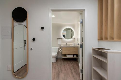 a bathroom with a mirror and a sink and a toilet at TownePlace Suites by Marriott Williston in Williston