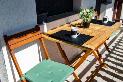 a wooden table with a coffee cup and a chair at Alba in Tryavna