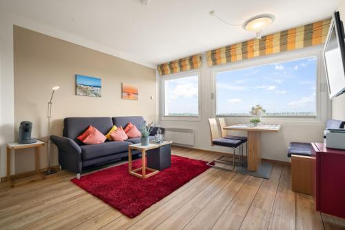 a living room with a couch and a red rug at Stranddistel 4 Hafenkoje in Burgtiefe auf Fehmarn 