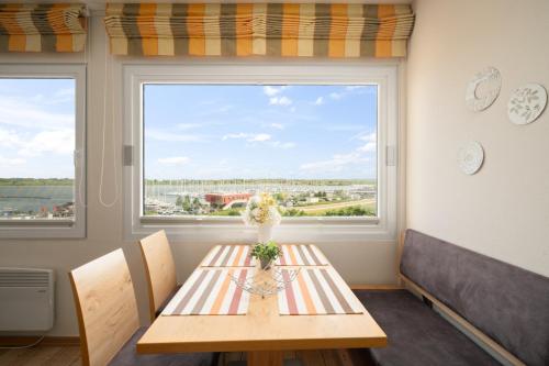 a dining room with a table and a large window at Stranddistel 4 Hafenkoje in Burgtiefe auf Fehmarn 