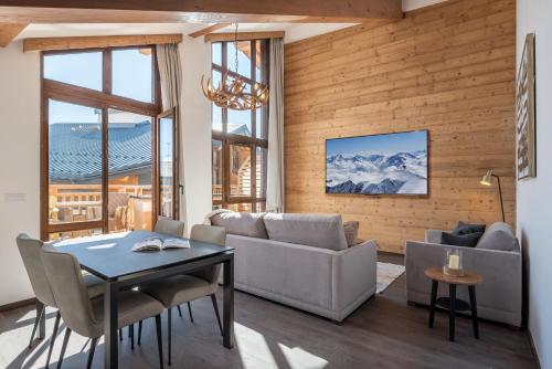 un salon avec un canapé et une table dans l'établissement Apartment Ascar Alpe d'Huez - by EMERALD STAY, à Huez