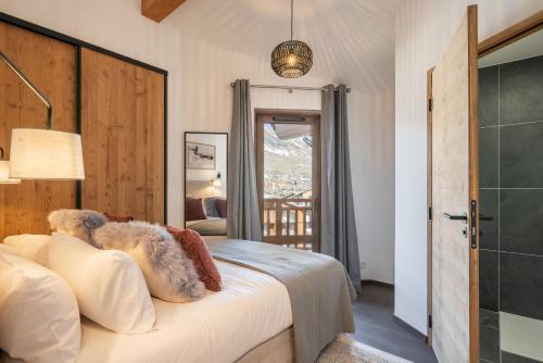 une chambre avec un lit et une porte vitrée avec une fenêtre dans l'établissement Apartment Ascar Alpe d'Huez - by EMERALD STAY, à Huez