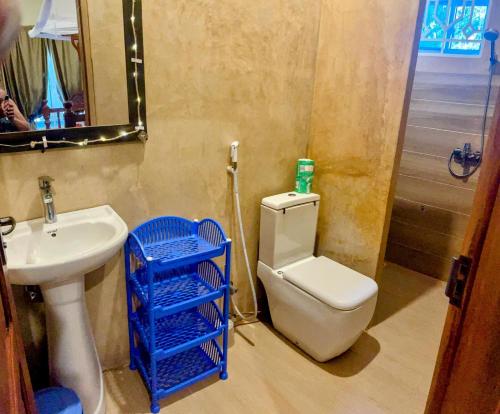 a bathroom with a white toilet and a sink at White Jaguar House in Bwejuu