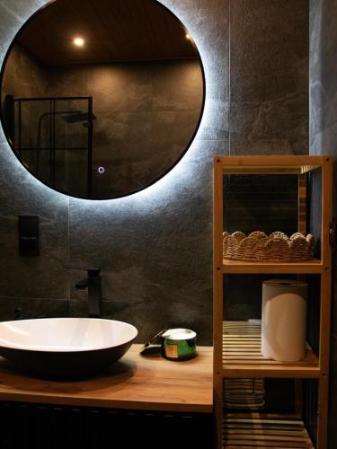 a bathroom with a sink and a large mirror at Hygge Sauna&Spa in Gleźnowo
