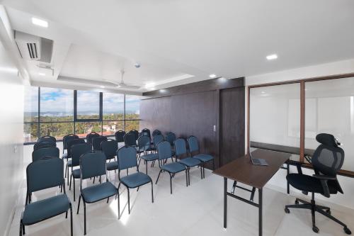 a conference room with chairs and a table and windows at BSG Porvorim Regency Hotel Goa in Porvorim