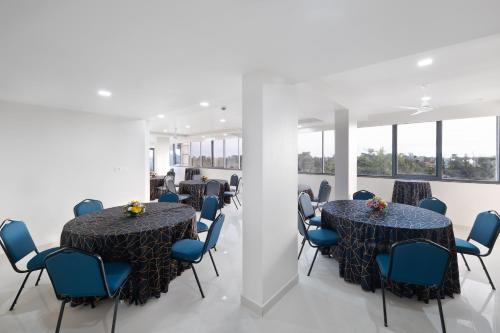a meeting room with two tables and blue chairs at BSG Porvorim Regency Hotel Goa in Porvorim