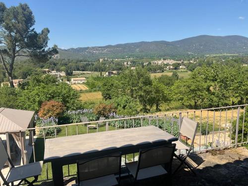 a table and chairs on a balcony with a view at L'Irisciabella in Lourmarin