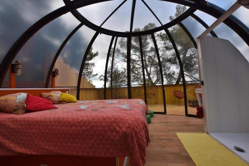 a bedroom with a bed in a round room at Logements insolites du Domaine de la Tuilière in Carnoules