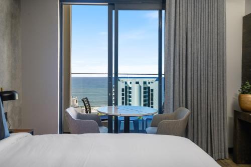 a hotel room with a bed and a large window at The Capital Pearls Hotel in Durban