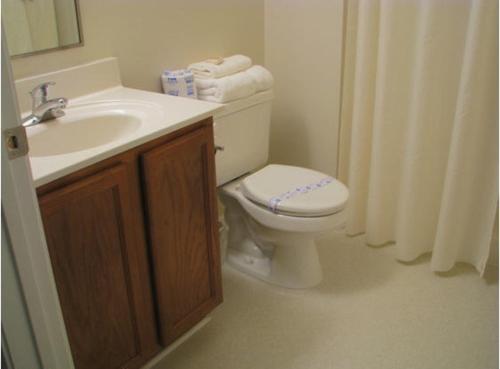 a bathroom with a white toilet and a sink at Affordable Suites Conover / Hickory in Conover