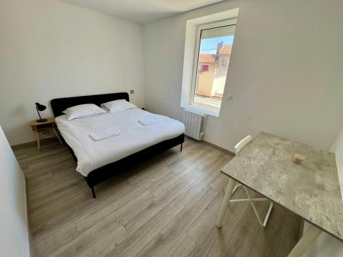 une chambre avec un lit, une table et une fenêtre dans l'établissement Le Bel'air - T3 pour 5 personnes, à Poitiers