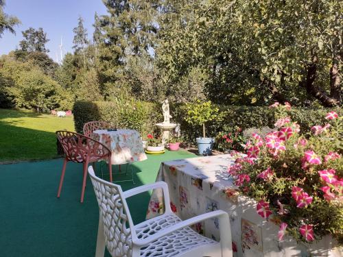 a patio with a table and chairs and flowers at 4 km zu A7 und A71, Idylle am Bach, großer Garten in Euerbach