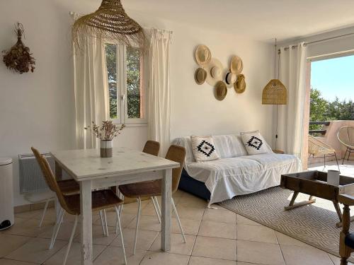 un salon avec une table et un canapé dans l'établissement Mini-villa à 5 minutes de la plage de Santa Giulia, à Porto-Vecchio