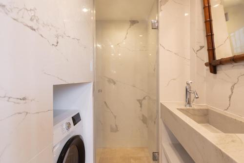 une salle de bain avec une machine à laver et un lavabo dans l'établissement Pick A Flat's House in Saint-Germain des Près - Impasse Paul Louis Courier, à Paris