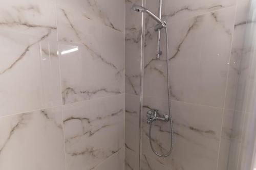 a bathroom with a shower with a glass door at Skyard - Central 2bd House in Kos