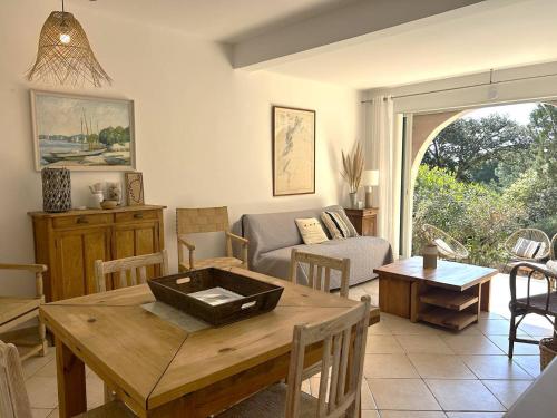 un salon avec une table et un canapé dans l'établissement Mini-villa à 5 minutes de la plage de Santa Giulia, à Porto-Vecchio