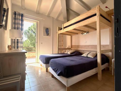 une chambre avec deux lits superposés et une fenêtre dans l'établissement Mini-villa à 5 minutes de la plage de Santa Giulia, à Porto-Vecchio