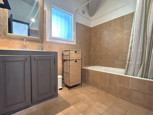 une salle de bain avec une baignoire et un lavabo et une baignoire dans l'établissement Mini-villa à 5 minutes de la plage de Santa Giulia, à Porto-Vecchio