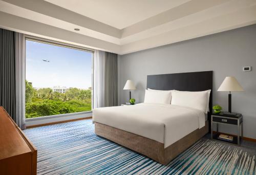 a hotel room with a bed and a large window at Grand Hyatt Mumbai Hotel and Residences in Mumbai