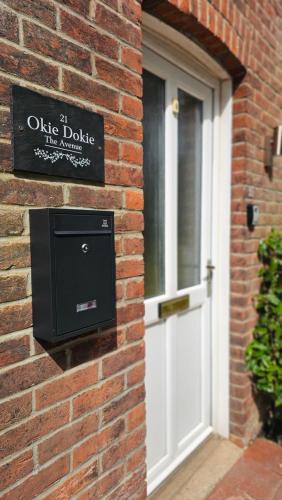 a sign on a brick wall next to a door at Okie Dokie - Charming seaside property in Sheringham