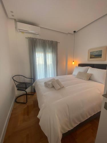 a large white bed in a room with a window at Neapoli Modern Apartment in Athens
