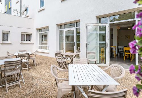 a patio with tables and chairs and windows at B&B HOTEL Tours Parc Expo St-Avertin in Saint-Avertin