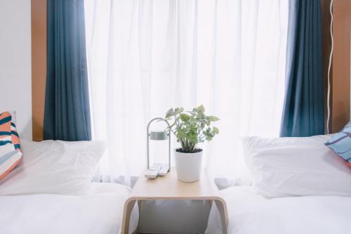 a room with two beds and a table with a potted plant at 6 minutes walk from Ichikawa Station Single-family house with 3 bedrooms and 1 living room Rich living facilities around in Ichikawa