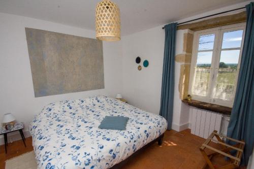a bedroom with a bed and a large window at Maison Le Garochet in Digoin