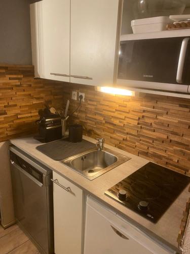 a kitchen with a sink and a microwave at Val Thorens Appartement Cosy centre station in Val Thorens