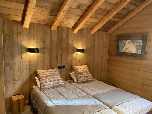 deux lits dans une chambre aux murs en bois dans l'établissement Chalet aux pieds des pistes Happy 2 alpes, à Les Deux Alpes